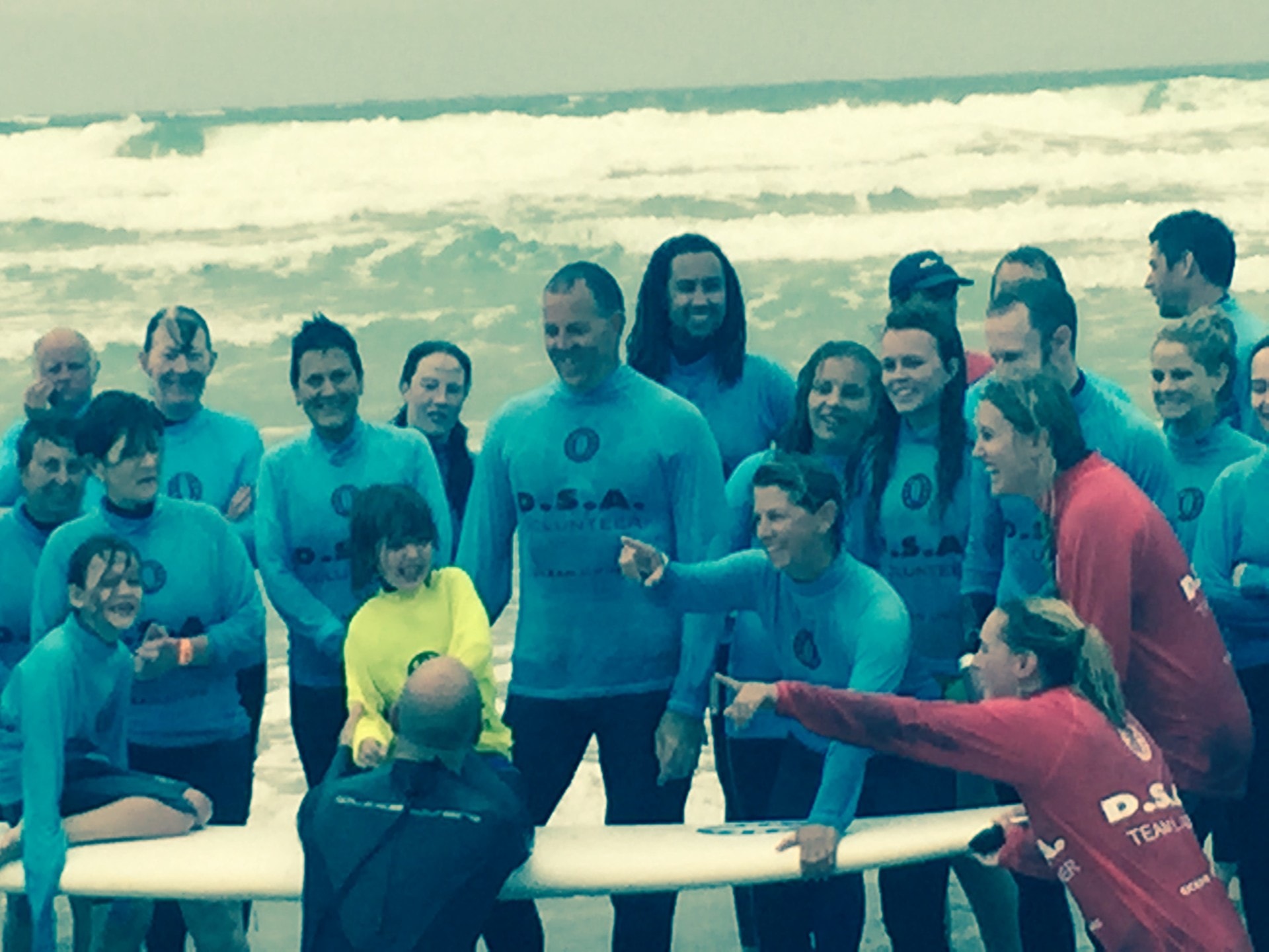 Large group of DSA participants and volunteers gathered on the beach