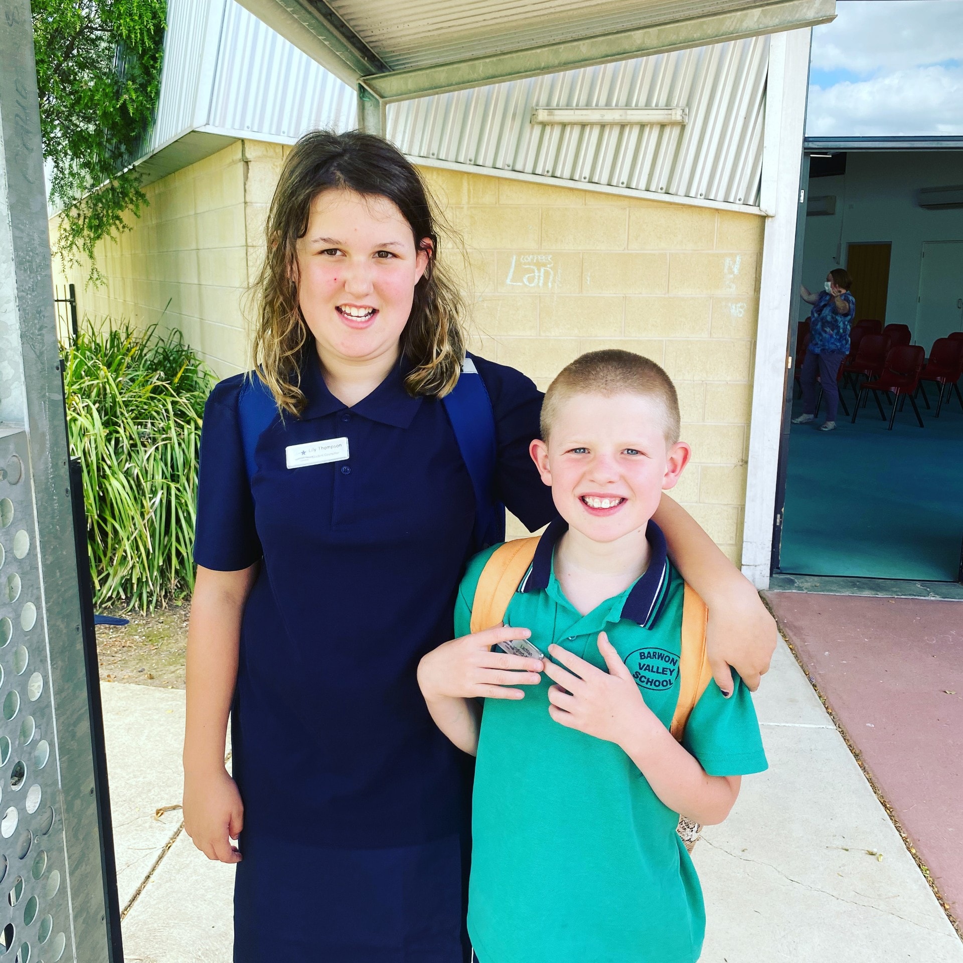Two young people smiling together outside school
