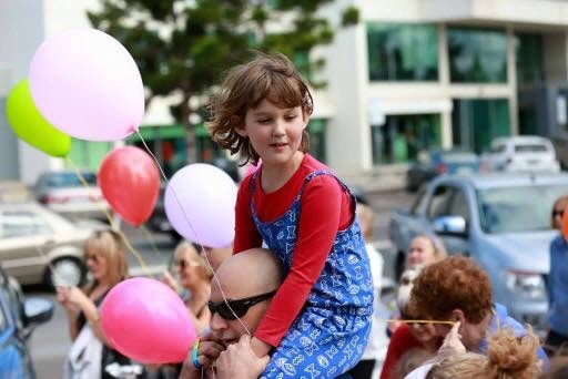 A child with balloons at a community celebration — joy and inclusion in action
